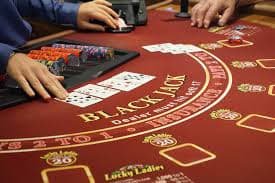 Player checking hand value and preparing to place next bet on sutra69
